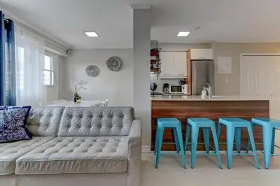 a living room with a couch and two blue stools at Refined Downtown 1BR Suite - Luxury Comfort in Montréal