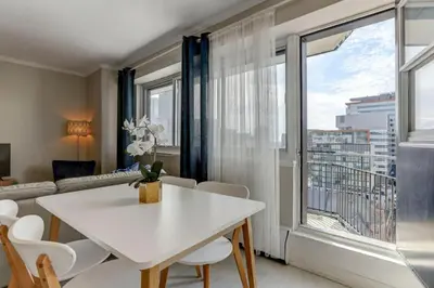 a living room with a white table and chairs and a large window at Refined Downtown 1BR Suite - Luxury Comfort in Montréal