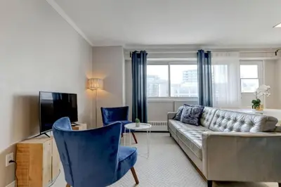 a living room with a couch and two blue chairs at Refined Downtown 1BR Suite - Luxury Comfort in Montréal