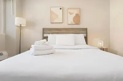 a bedroom with a white bed with towels on it at Luxury Downtown 1BR Residence - Urban Comfort in Montréal