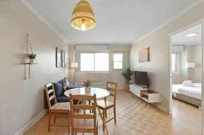 a living room with a table and a bedroom at Luxury Downtown 1BR Residence - Urban Comfort in Montréal
