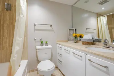 a bathroom with a toilet and a sink and a mirror at Modern 1BR Downtown Suite - High-Speed Wi-Fi in Montréal