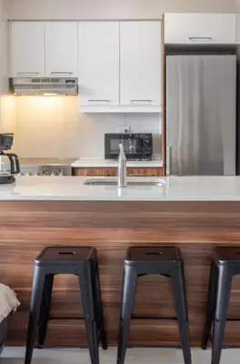 a kitchen with a counter with two stools in it at Modern 1BR Downtown Suite - High-Speed Wi-Fi in Montréal