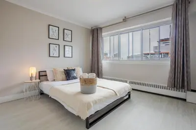 a bedroom with a bed and a large window at Modern 1BR Downtown Suite - High-Speed Wi-Fi in Montréal