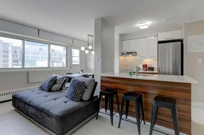 a living room with a couch and a kitchen at Modern 1BR Downtown Suite - High-Speed Wi-Fi in Montréal