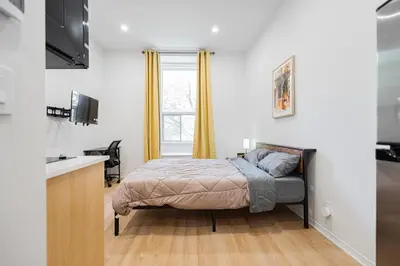 a small bedroom with a bed and a window at Studio tout équipe pour 2- Location par semaine- Parking gratuit in Montréal