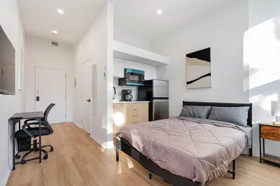 a bedroom with a bed and a desk and a chair at Studio style pour 2- Location par Semaine-Parking gratuit in Montréal