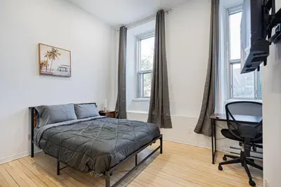 a bedroom with a bed and a desk and windows at Chic Studio pour 2- 7 jours- Parking gratuit in Montréal