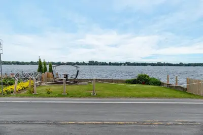 a view of a body of water with a fence at Le Repere du Lac - Lake View Access & Spa in Venise-en-Québec