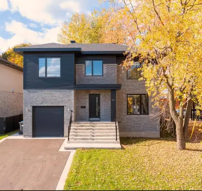 a black house with a driveway and a tree at Spacious 4 Bedroom Family Retreat, Minutes from Montréal in Longueuil