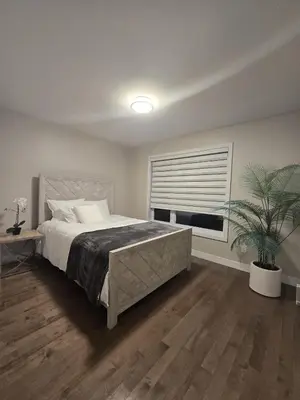 a bedroom with a large bed and a potted plant at Spacious 4 Bedroom Family Retreat, Minutes from Montréal in Longueuil