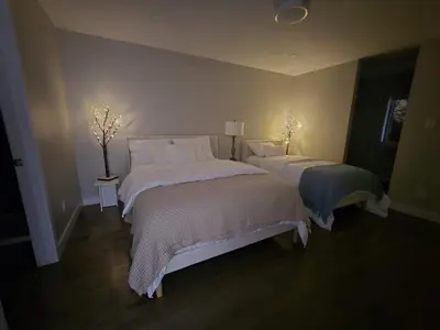 a bedroom with two beds with white comforters at Spacious 4 Bedroom Family Retreat, Minutes from Montréal in Longueuil