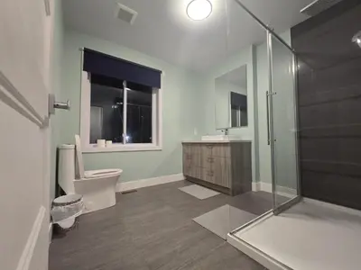 a bathroom with a shower and a toilet and a sink at Spacious 4 Bedroom Family Retreat, Minutes from Montréal in Longueuil
