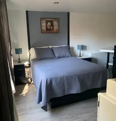 a bedroom with a bed with a blue blanket at Bethel in Sherbrooke
