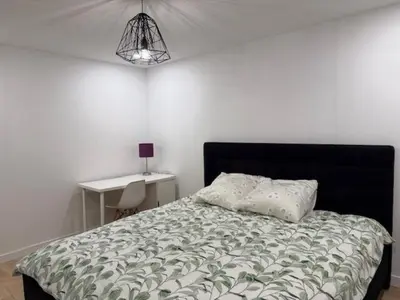 a bedroom with a bed and a desk with a lamp at Apartment with 3 bedrooms for long stays in Montréal