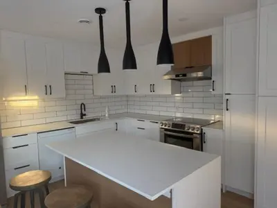 a kitchen with white cabinets and a white counter top at Apartment with 3 bedrooms for long stays in Montréal