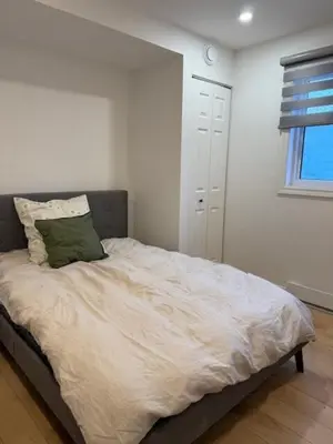 a bedroom with a bed with a green pillow on it at Apartment with 3 bedrooms for long stays in Montréal