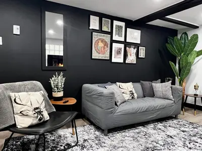 a living room with a gray couch and black walls at Edinburgh in Drummondville