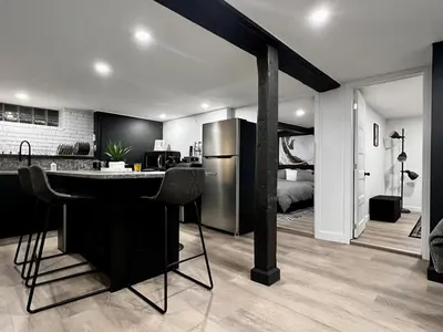 a kitchen with a bar with a refrigerator and a bedroom at Edinburgh in Drummondville