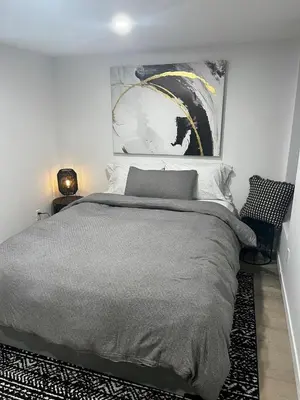 a bedroom with a bed and a painting on the wall at Edinburgh in Drummondville