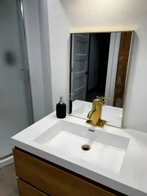 a bathroom with a sink and a mirror at Edinburgh in Drummondville