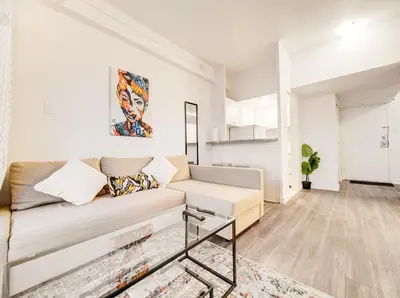 a living room with a couch and a painting on the wall at Vivez la ville depuis le centre in Montréal