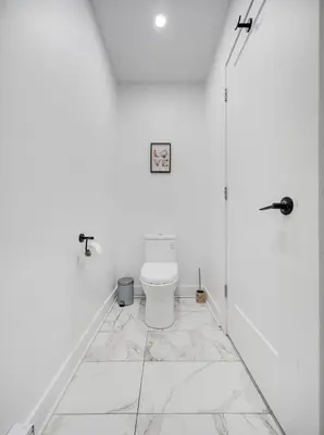 a bathroom with a toilet in a white room at Confort moderne au cœur de Montréal in Montréal