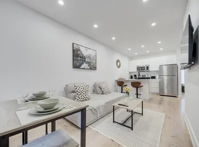 a white living room with a couch and a table at Confort moderne au cœur de Montréal in Montréal
