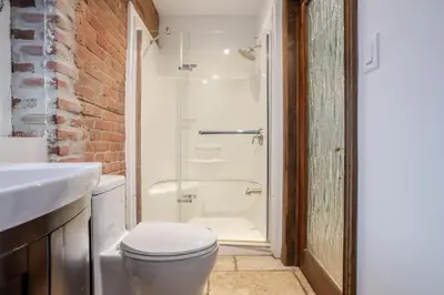 a bathroom with a shower and a toilet and a sink at Bright Montreal Loft, Trendy Downtown Escape in Montréal