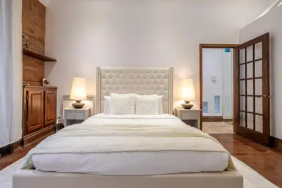 a bedroom with a large white bed with two lamps at Bright Montreal Loft, Trendy Downtown Escape in Montréal