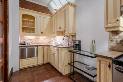 a kitchen with wooden cabinets and stainless steel appliances at Bright Montreal Loft, Trendy Downtown Escape in Montréal