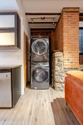a washer and dryer in a room with a brick wall at Downtown Montreal Gem, Walk Everywhere Easily in Montréal