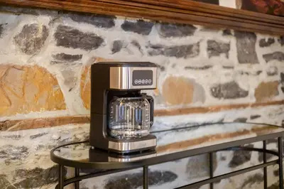 a coffee maker on a table against a stone wall at Downtown Montreal Gem, Walk Everywhere Easily in Montréal