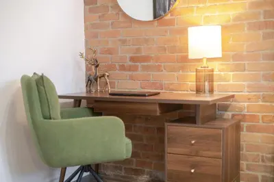 a desk with a chair and a lamp and a brick wall at Downtown Montreal Gem, Walk Everywhere Easily in Montréal