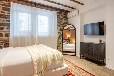 a bedroom with a large bed and a mirror at Downtown Montreal Gem, Walk Everywhere Easily in Montréal
