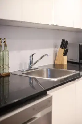 a stainless steel sink in a kitchen next to a microwave at Urban Haven, Modern Comfort in Downtown MTL in Montréal