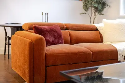 a brown couch with two pillows on it in a living room at Urban Haven, Modern Comfort in Downtown MTL in Montréal