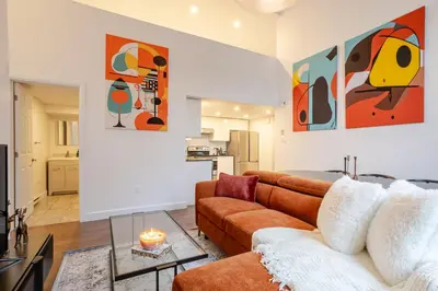 a living room with a couch and a table at Urban Haven, Modern Comfort in Downtown MTL in Montréal