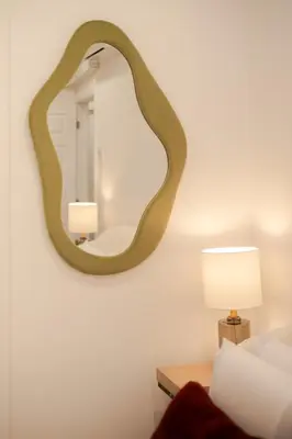 a mirror hanging on a wall next to a bed at Stylish Retreat Near Crescent & Sainte-Catherine in Montréal