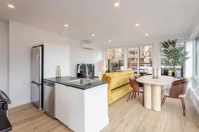 a kitchen with a sink and a table with chairs at Montreal Downtown Haven, Walk to All Attractions in Montréal