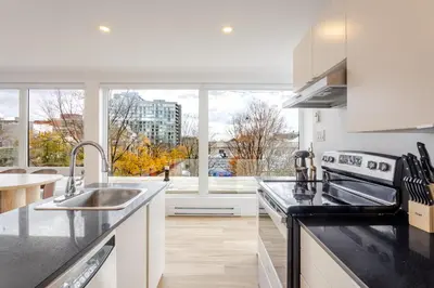 a kitchen with a sink and a large window at Montreal Downtown Haven, Walk to All Attractions in Montréal