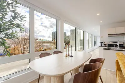 a dining room with a table and chairs and large windows at Montreal Downtown Haven, Walk to All Attractions in Montréal