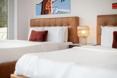 two beds in a hotel room with white sheets at Montreal Downtown Haven, Walk to All Attractions in Montréal