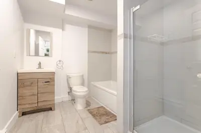 a white bathroom with a toilet and a shower at Chic City Hideaway, Vibrant Heart of Montreal in Montréal