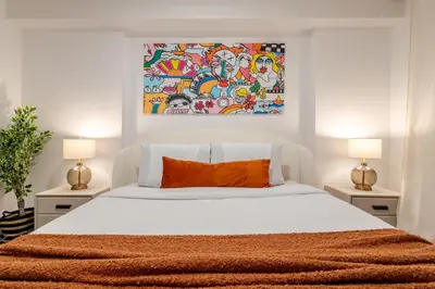 a bedroom with a bed with a painting on the wall at Chic City Hideaway, Vibrant Heart of Montreal in Montréal