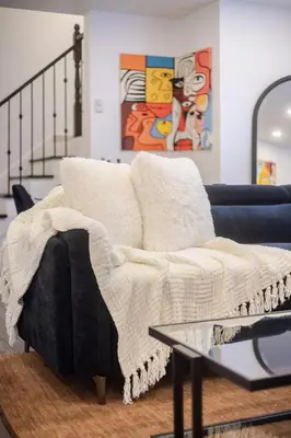 a couch with a blanket on it in a living room at Chic City Hideaway, Vibrant Heart of Montreal in Montréal
