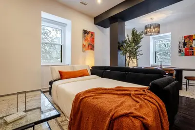 a living room with a bed and a couch at Elegant Downtown Stay, Near Bell Centre MTL in Montréal
