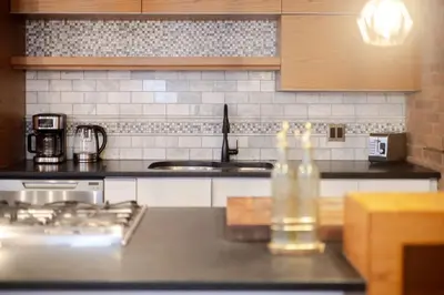a kitchen with a bottle of water on a counter at Elegant Downtown Stay, Near Bell Centre MTL in Montréal