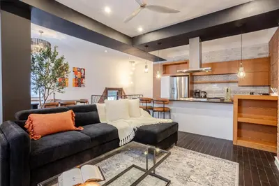 a living room with a couch and a kitchen at Elegant Downtown Stay, Near Bell Centre MTL in Montréal