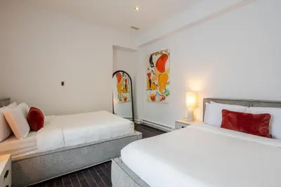 a bedroom with two beds and a couch at Elegant Downtown Stay, Near Bell Centre MTL in Montréal